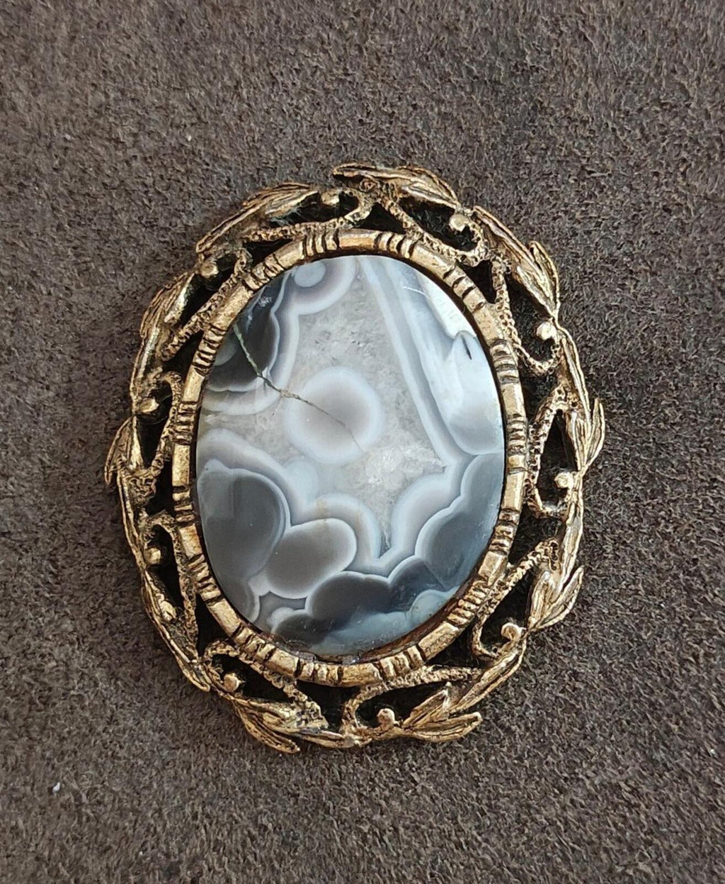 Vintage framed agate cabochon pendant, close-up of oval blue stone with goldtone frame