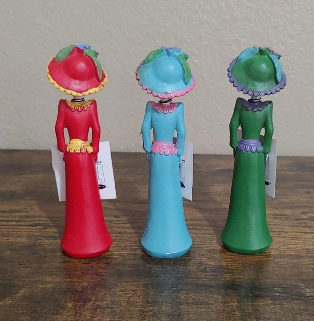 Set of three Day of the Dead lady figurines, viewed from front with red, blue, green dresses