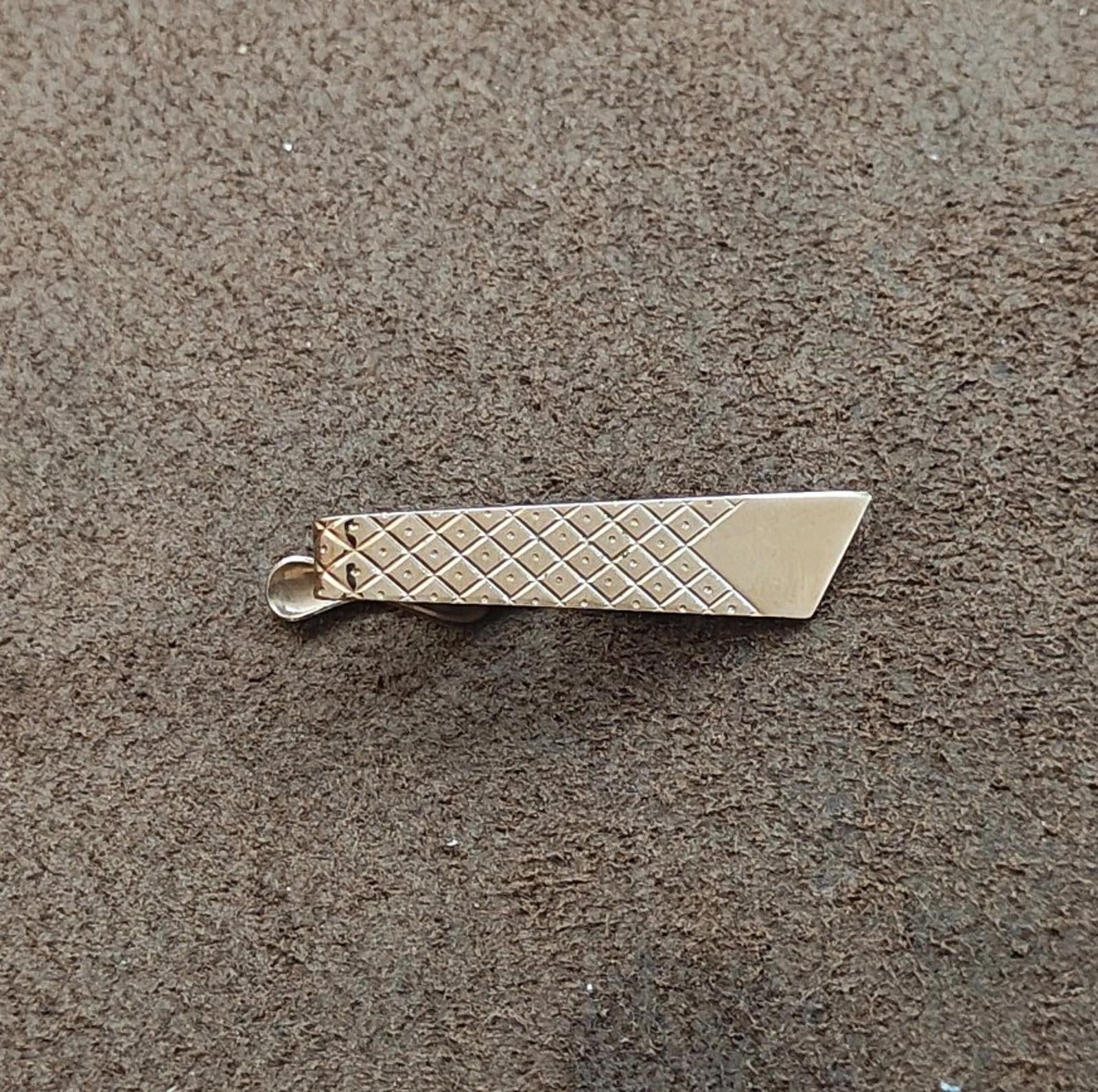 Silver-tone tie bar clip featuring a diamond lattice pattern and prong clip back