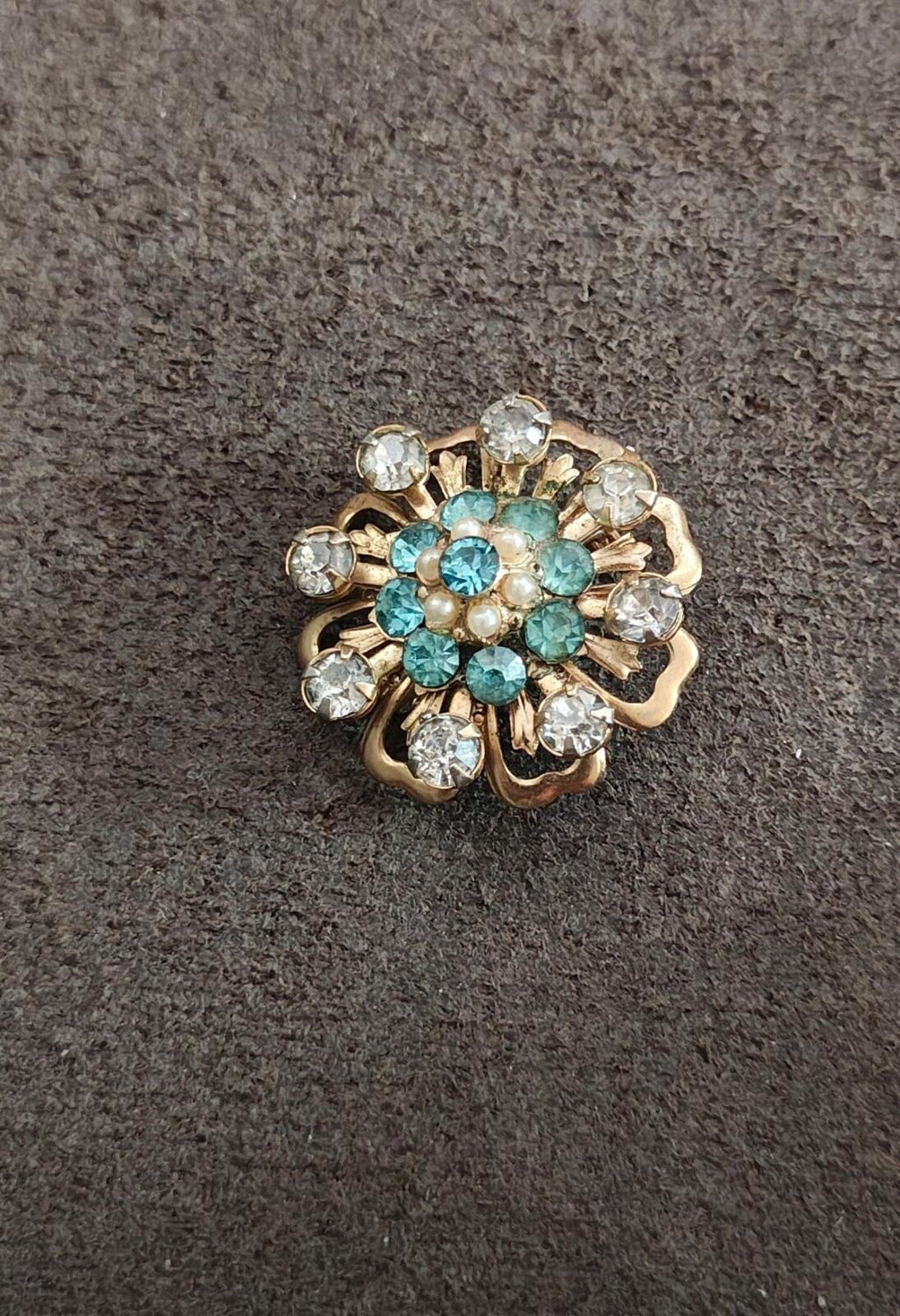 Gold-tone floral sunburst pin with teal stones, faux pearls, and clear rhinestone accents
