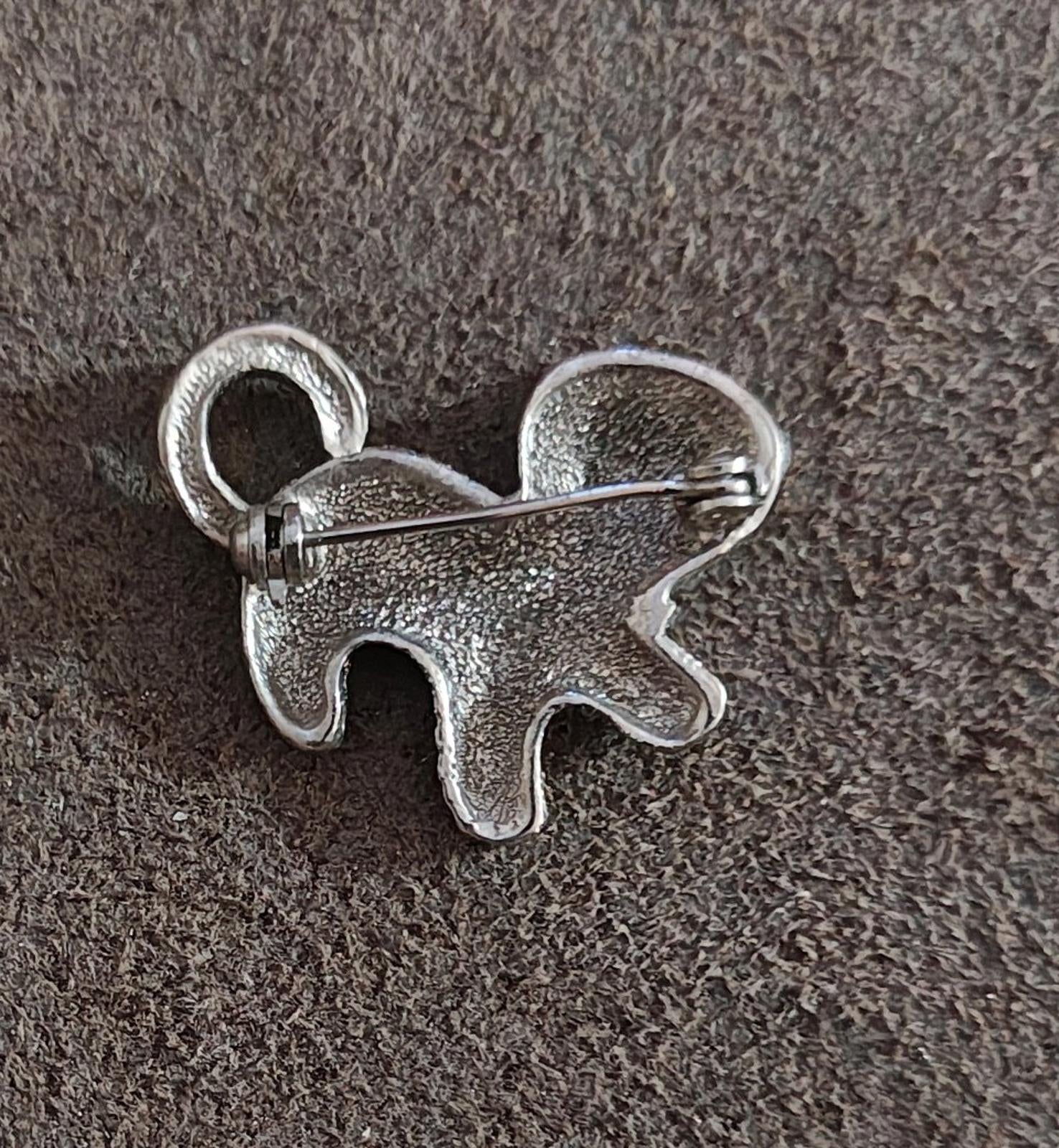 Silver-tone cat brooch pin back with safety clasp and pin needle exposed.