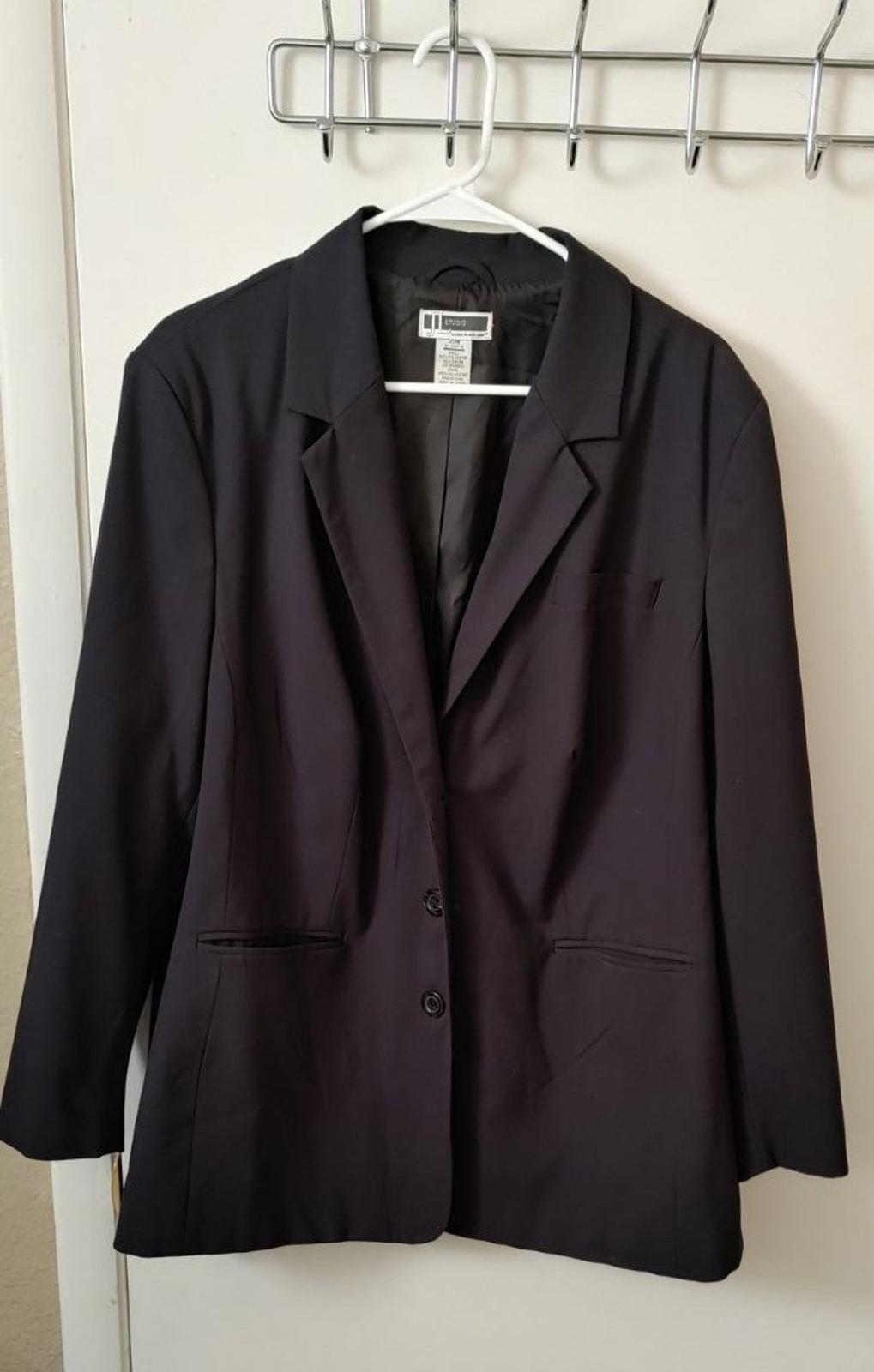 Black single-breasted blazer with notched lapels and flap pockets.