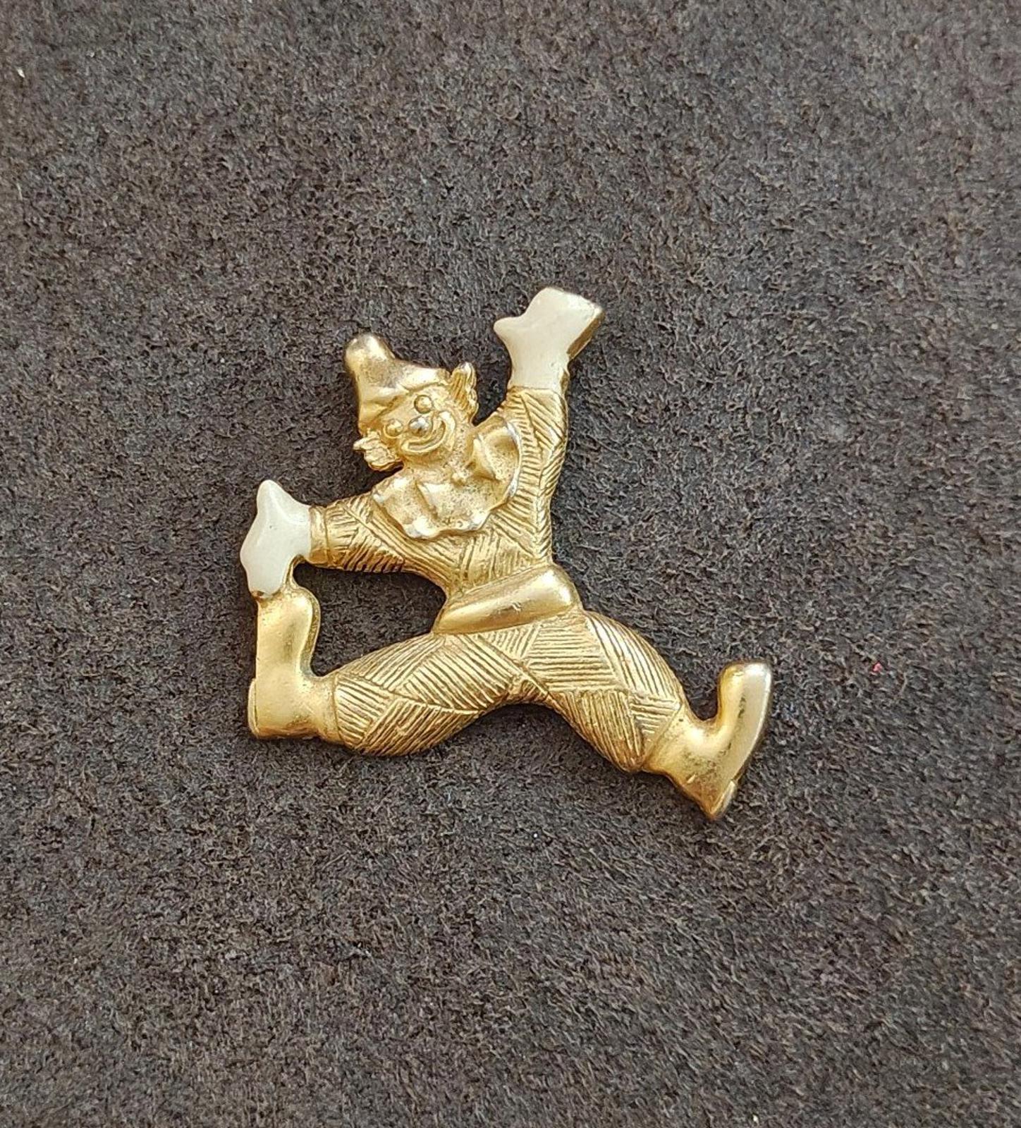 Gold tone clowning around enamel pendant with white enamel hands and shoes, angled side view