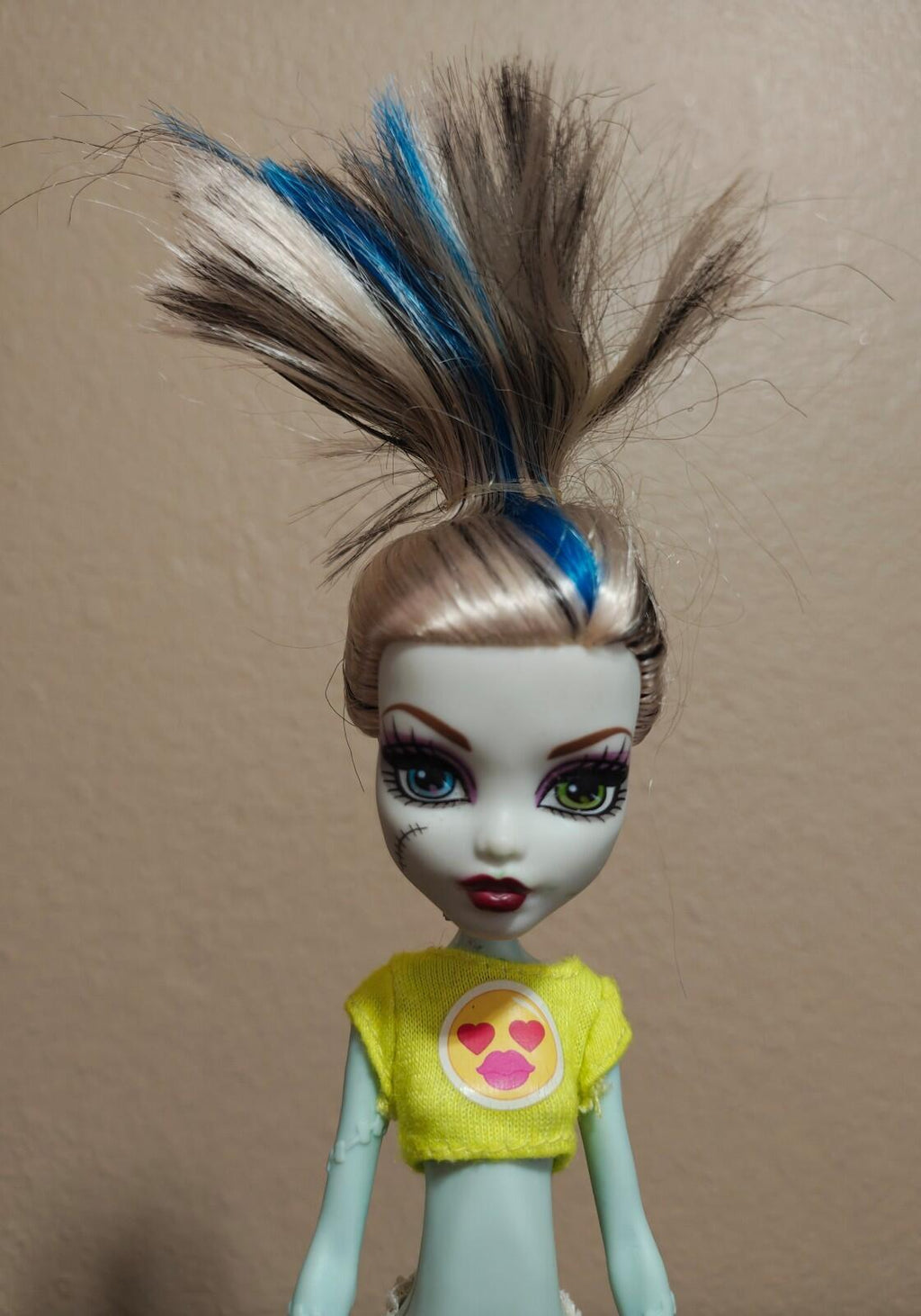 Frankie Stein doll close-up, green shirt with heart logo, blue streak hair