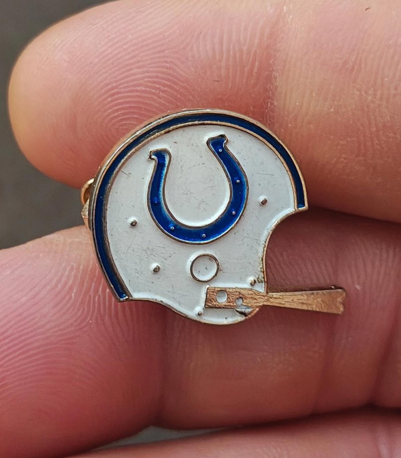 Gold-tone enamel tie clip featuring a white helmet with blue horseshoe graphic