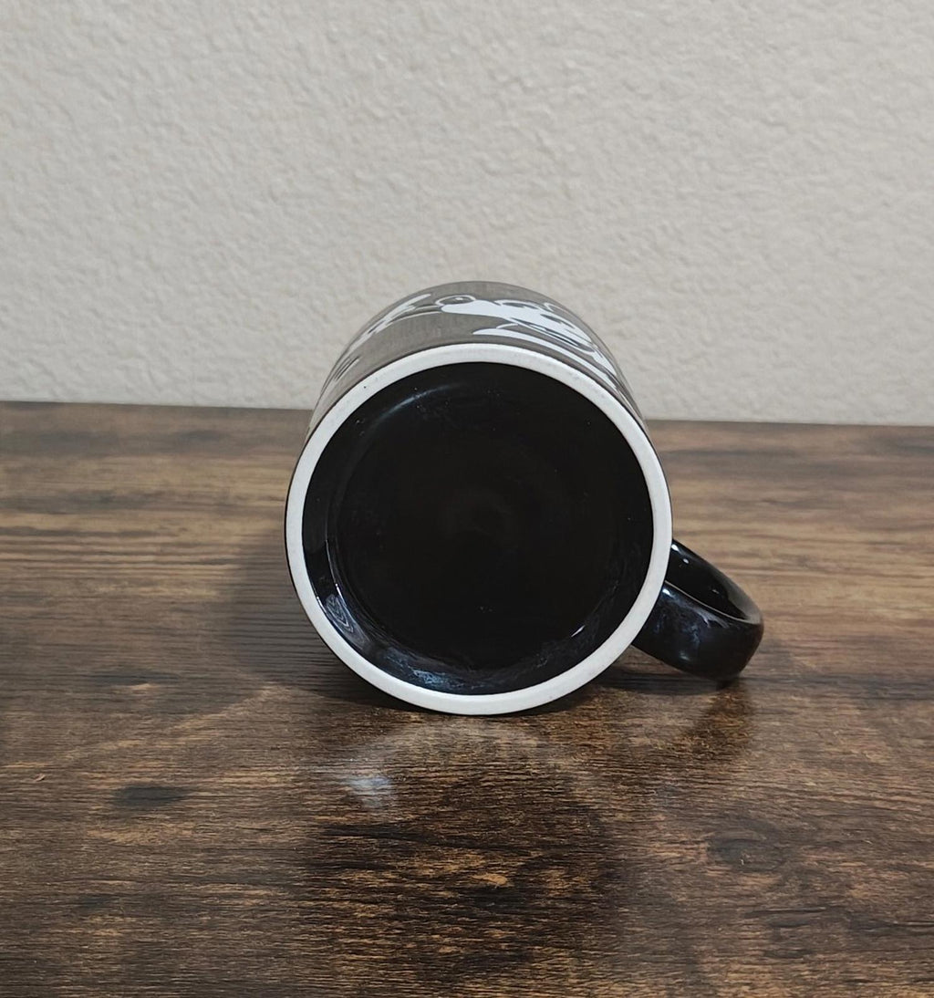 Reverse view of black mug with white rim trim and glossy interior