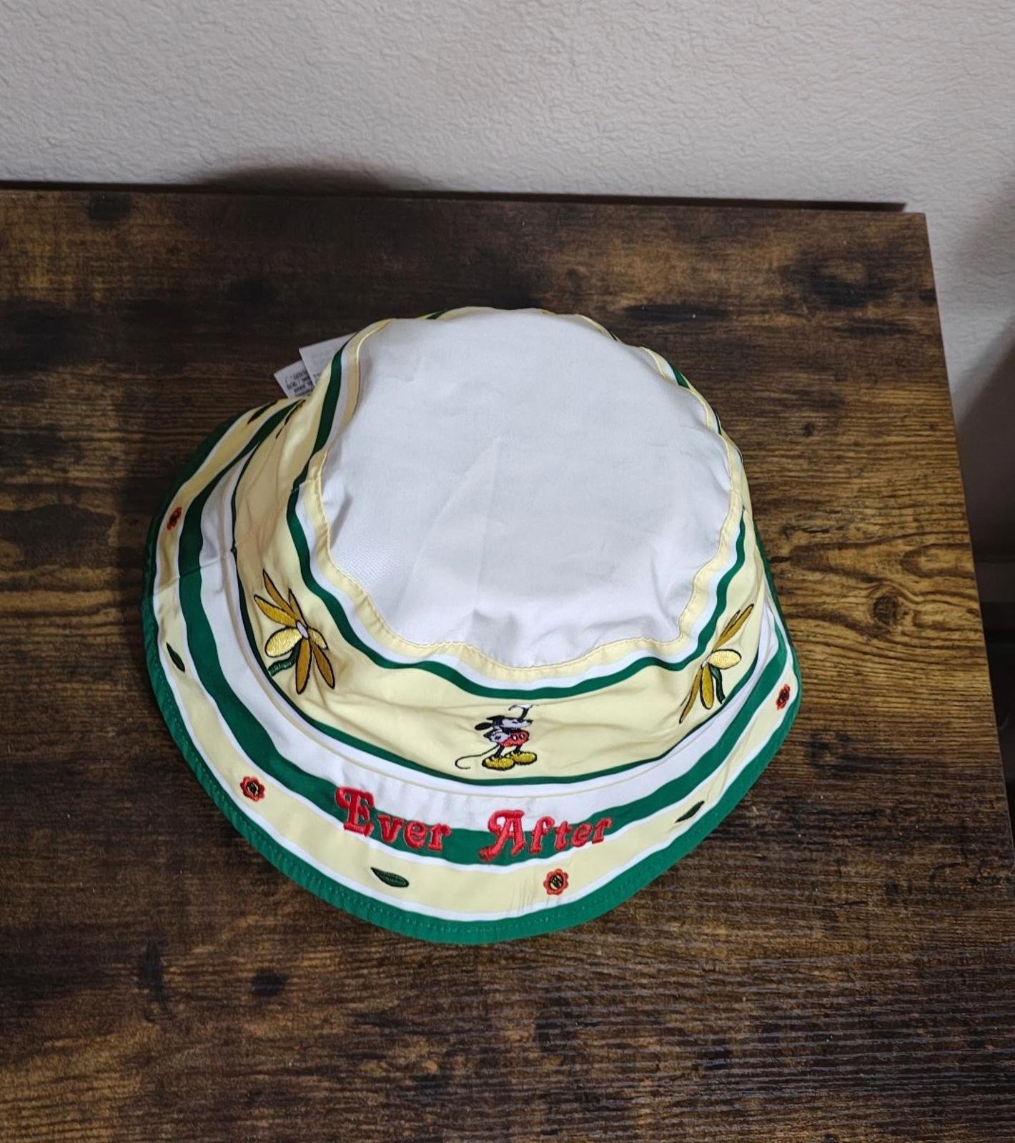 Cream bucket hat turned underside-up with green trim and stripe bands, Mickey and flowers