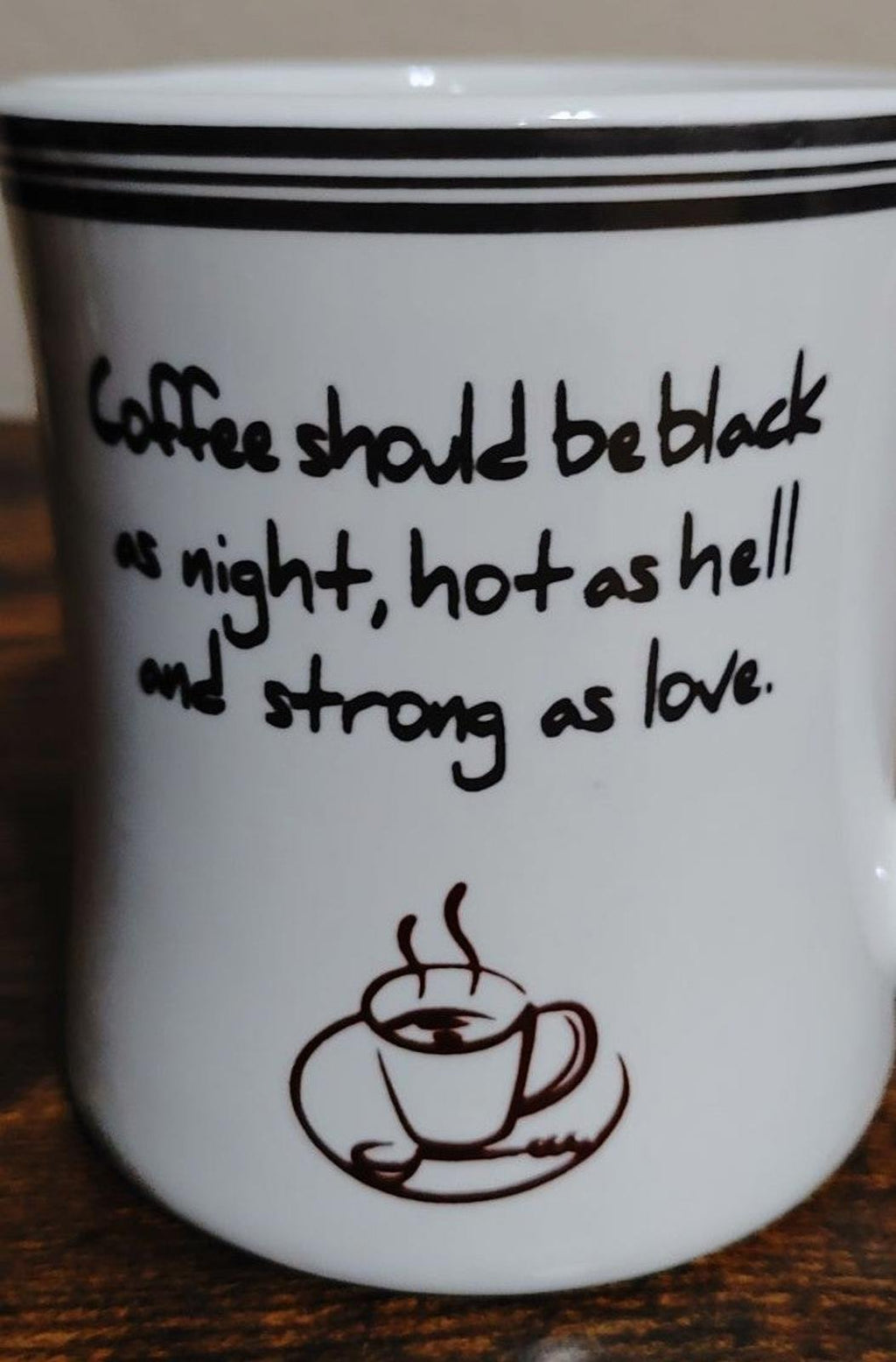 White mug close-up showing black quote text and coffee cup icon