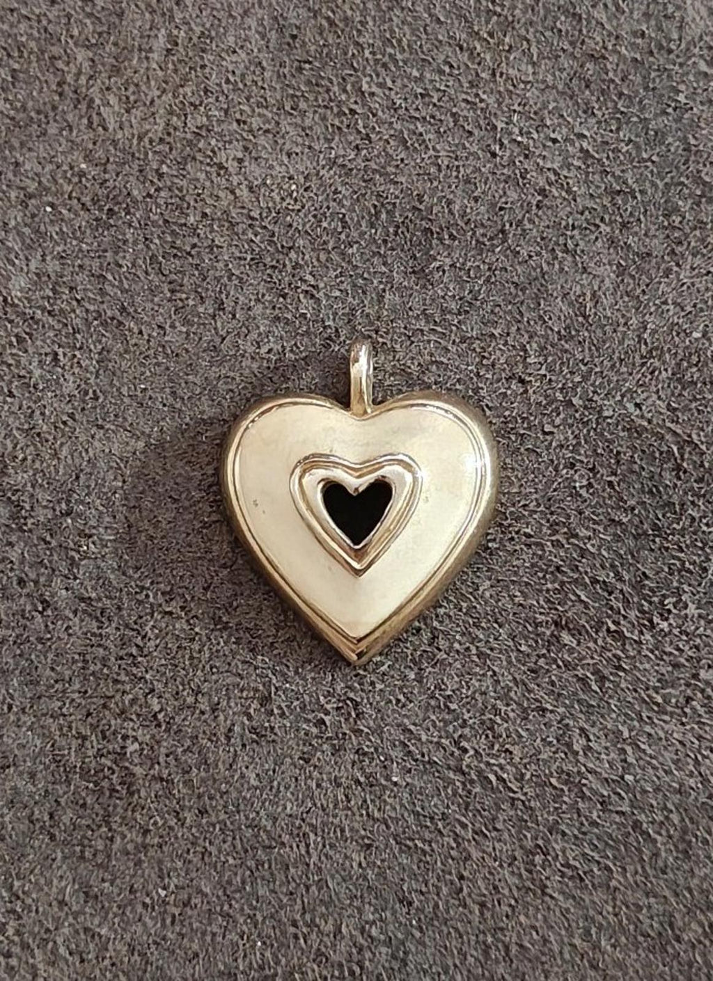 Gold tone heart pendant with white enamel face and black heart center, hanging loop