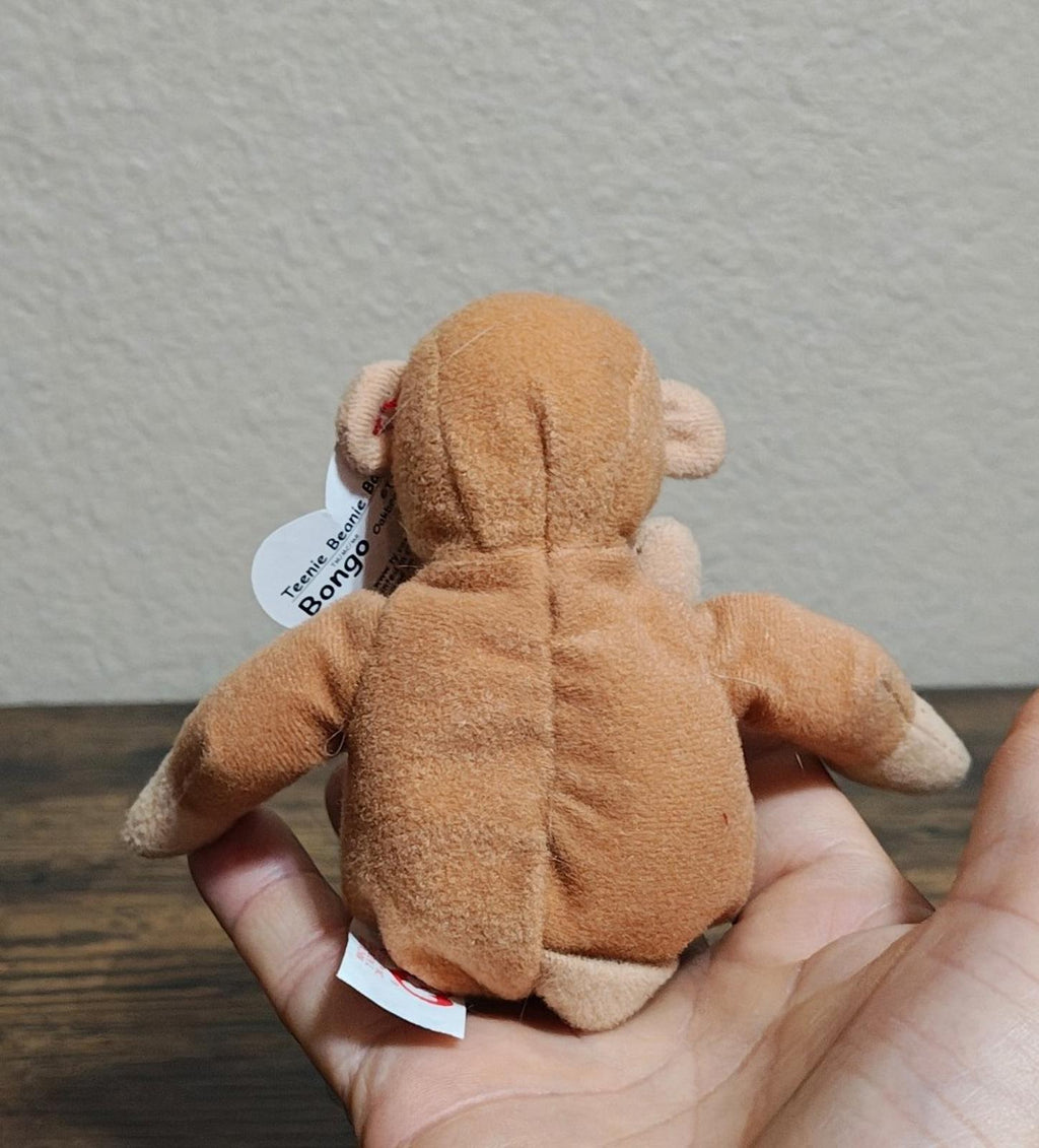 Brown Ty plush monkey back view with small white tag, held in hands