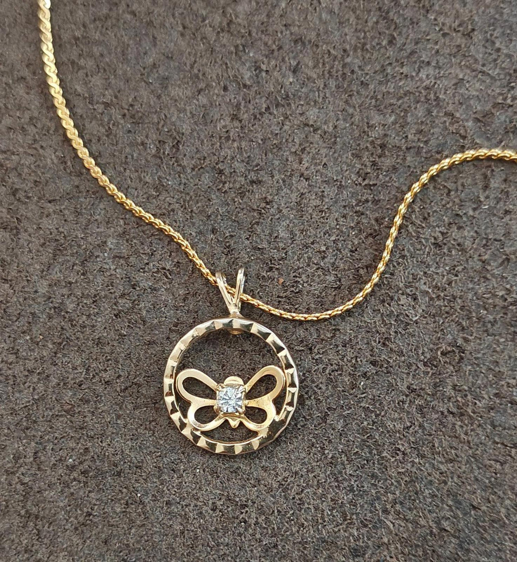 Gold-tone round pendant necklace with open circle frame, bow butterfly design, clear rhinestone