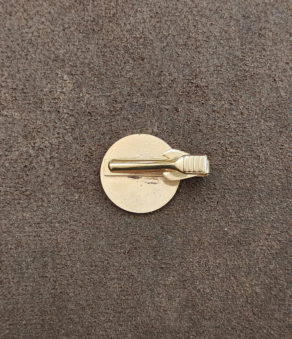 Gold-tone back of a round tie clip with metal bar and clasp pin