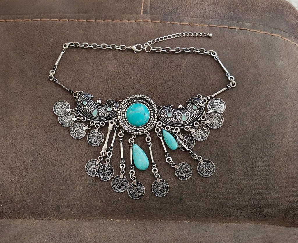 Silver-tone boho bib necklace with teal oval center stone and dangling coin charms
