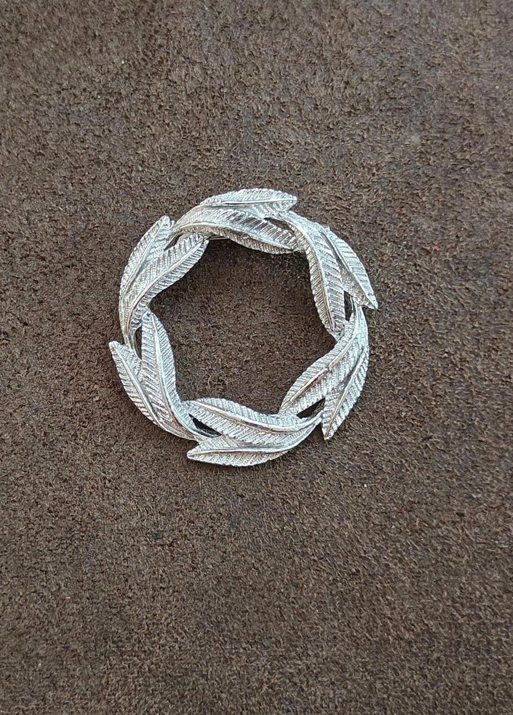 Silver-tone circular leaf wreath pin brooch with full open center view