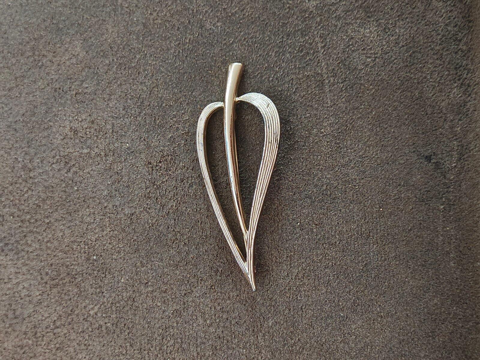 Gold open leaf brooch with tall center stem and leaf-shaped textured outline.