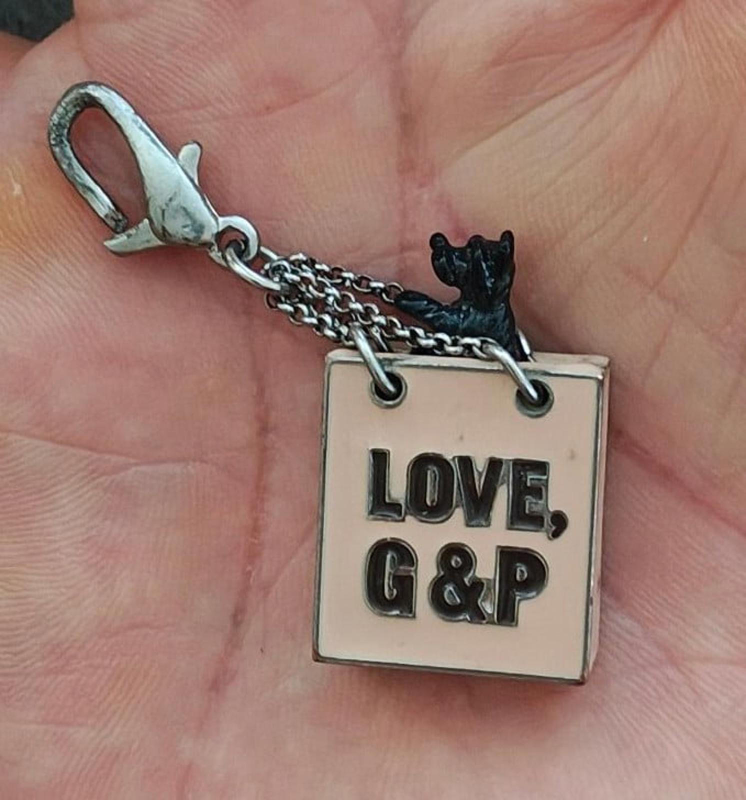 Juicy Couture bag charm with chain and square tag reading "LOVE, G&P" with dog