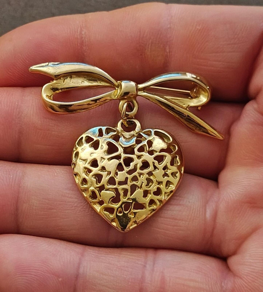 Gold tone ribbon bow brooch with dangling openwork heart filigree pendant