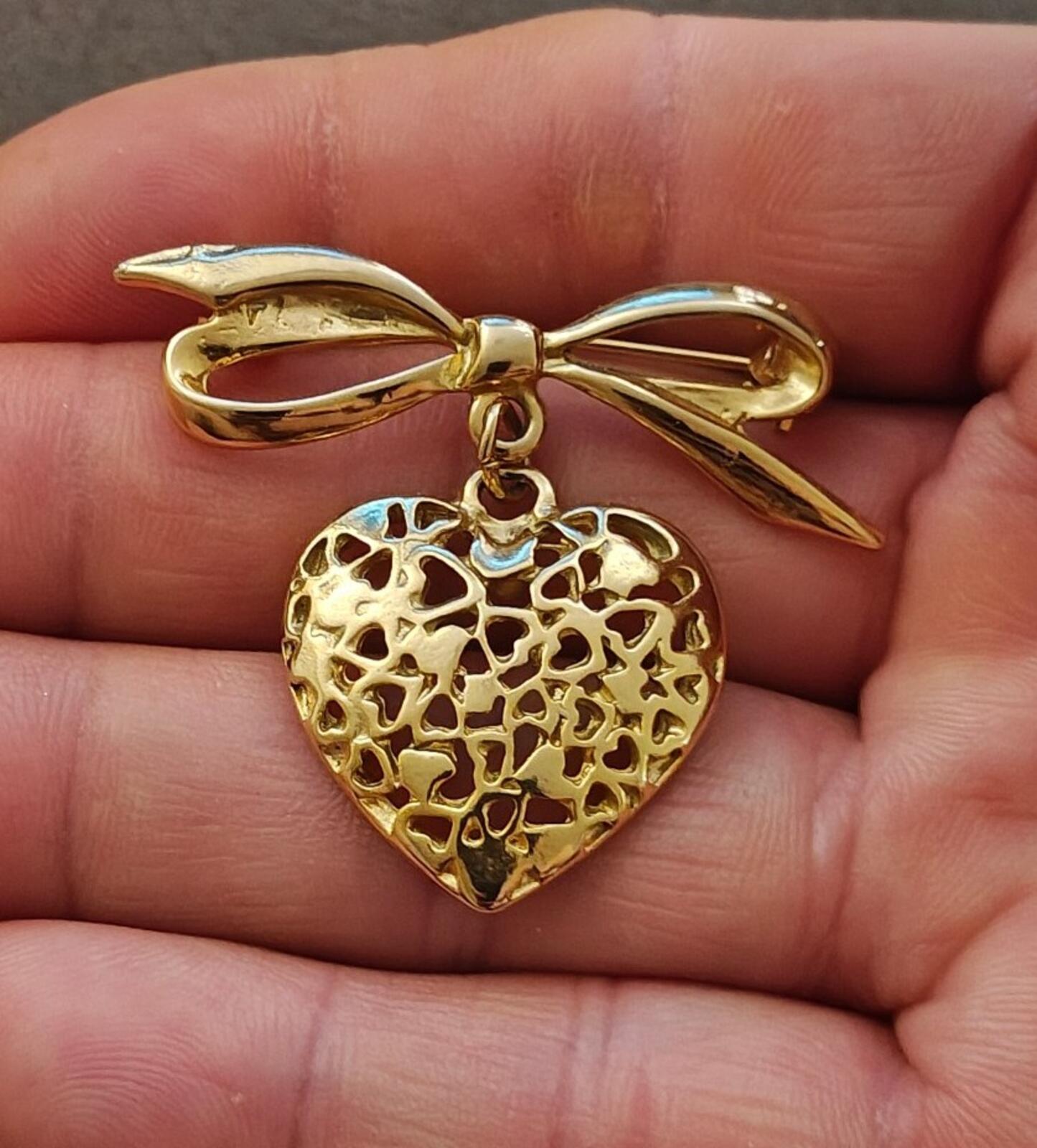 80s Gold Tone Ribbon Bow Brooch With a Dangling Openwork Filigree Heart Pendant