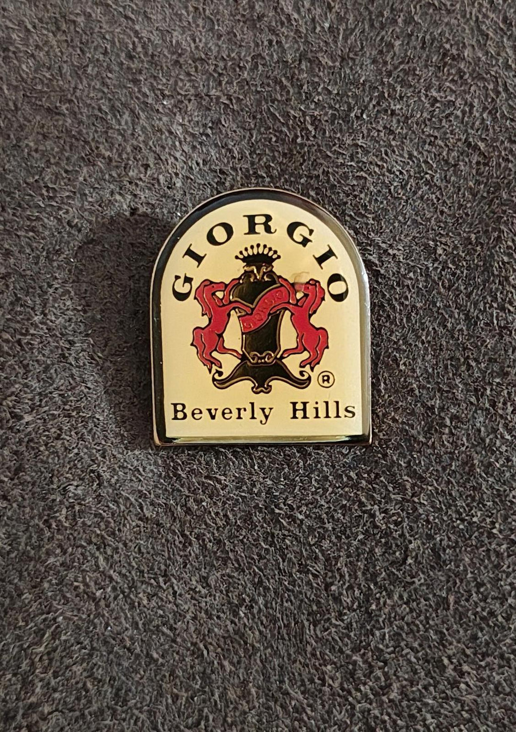 Gold-tone enamel lapel pin featuring a red and black lion crest and "Beverly Hills"
