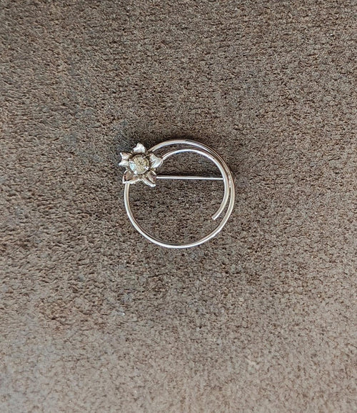 Silver circle brooch with three-piece flower and light rhinestone center
