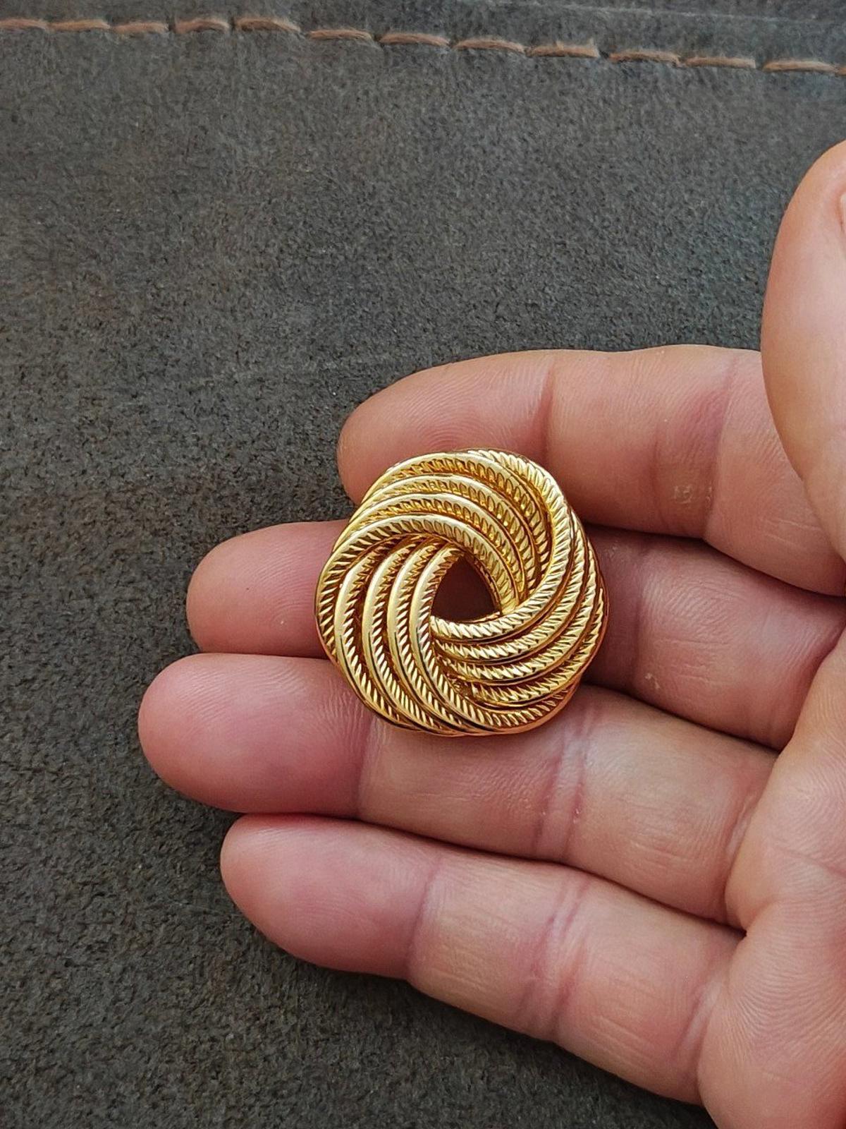 Gold tone rope swirl brooch pin viewed from the side, spiral pattern front