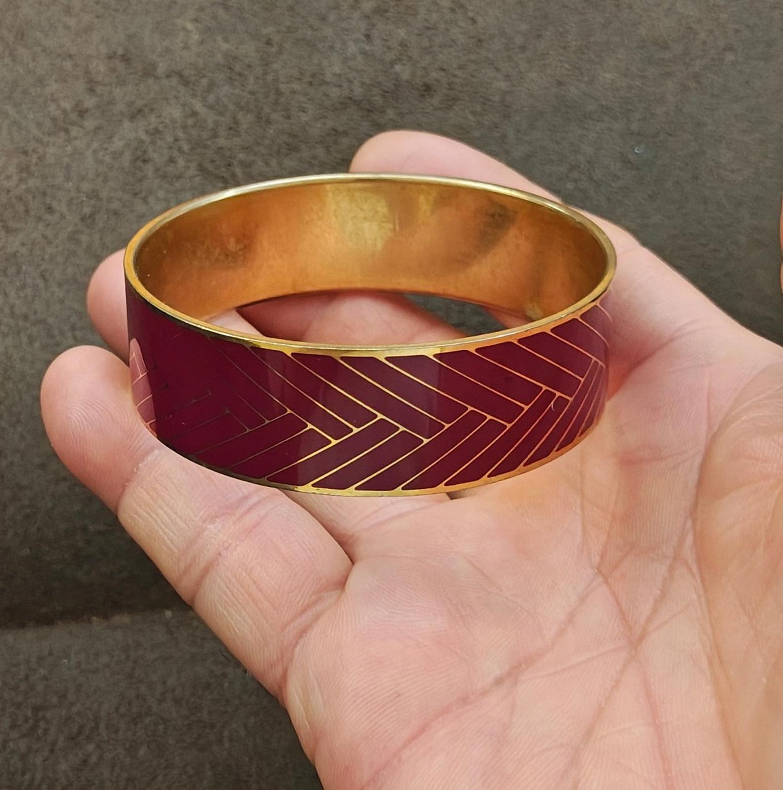 Gold-tone inner rim burgundy herringbone enamel bangle bracelet, side view.