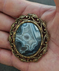 Vintage framed agate cabochon pendant with oval blue stone in goldtone leaf setting