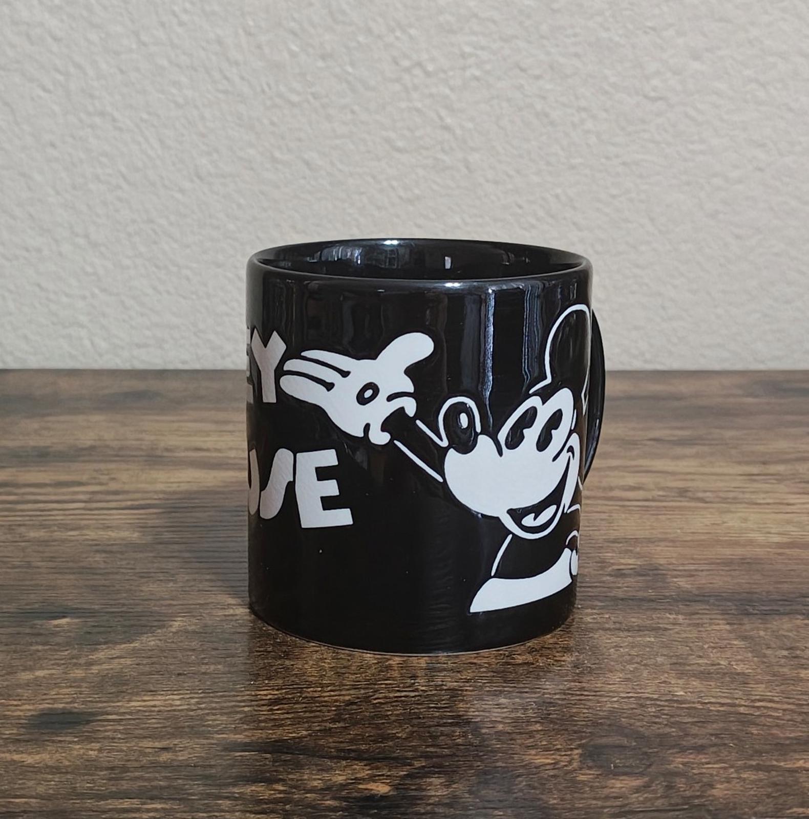 Black mug with partial white Mickey Mouse graphic and “E” lettering