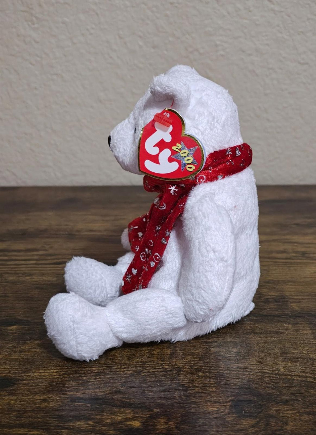 White bear plush side pose wearing red patterned scarf and heart tag