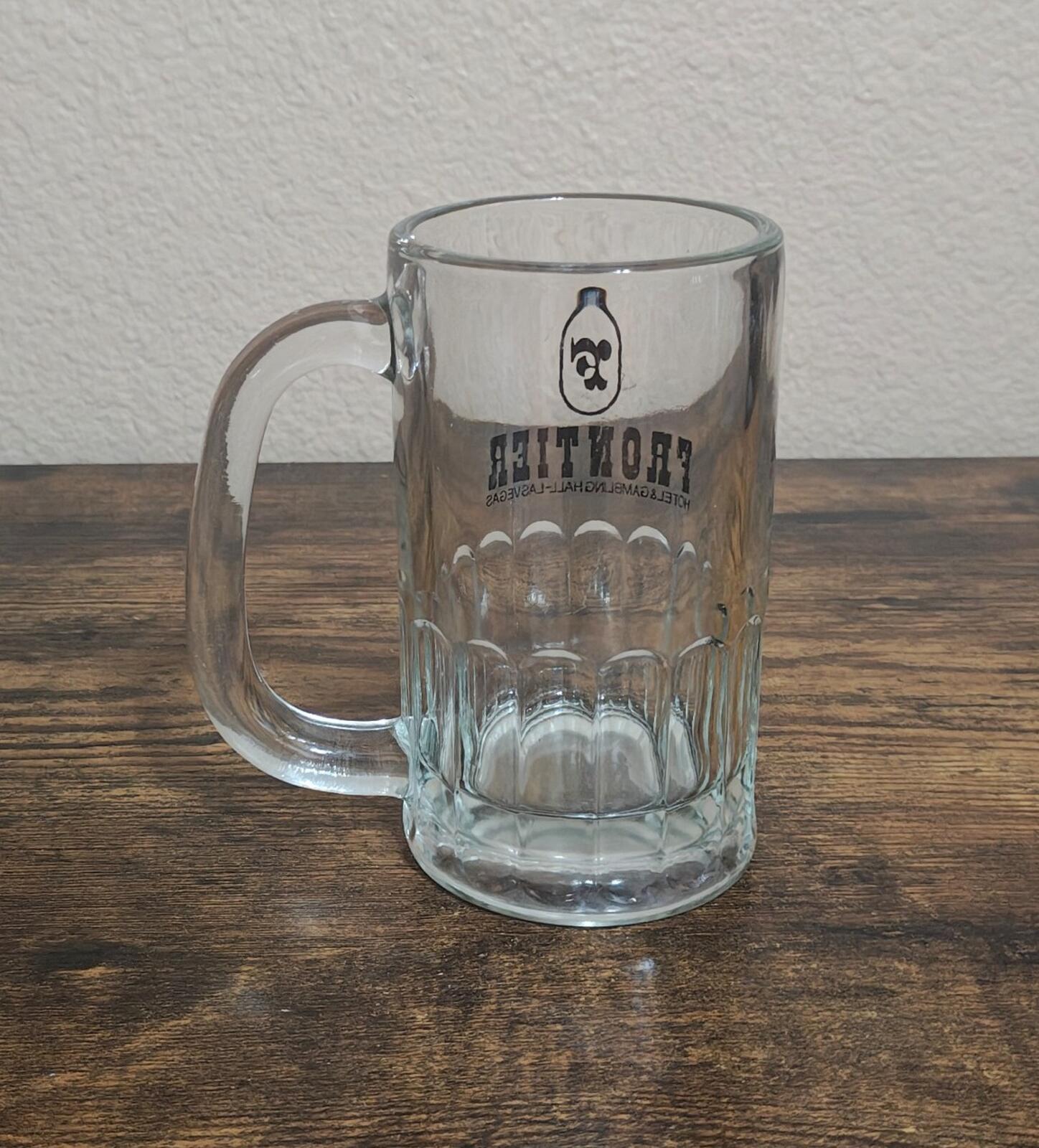 Clear glass beer mug with Frontier logo and hotel text on side