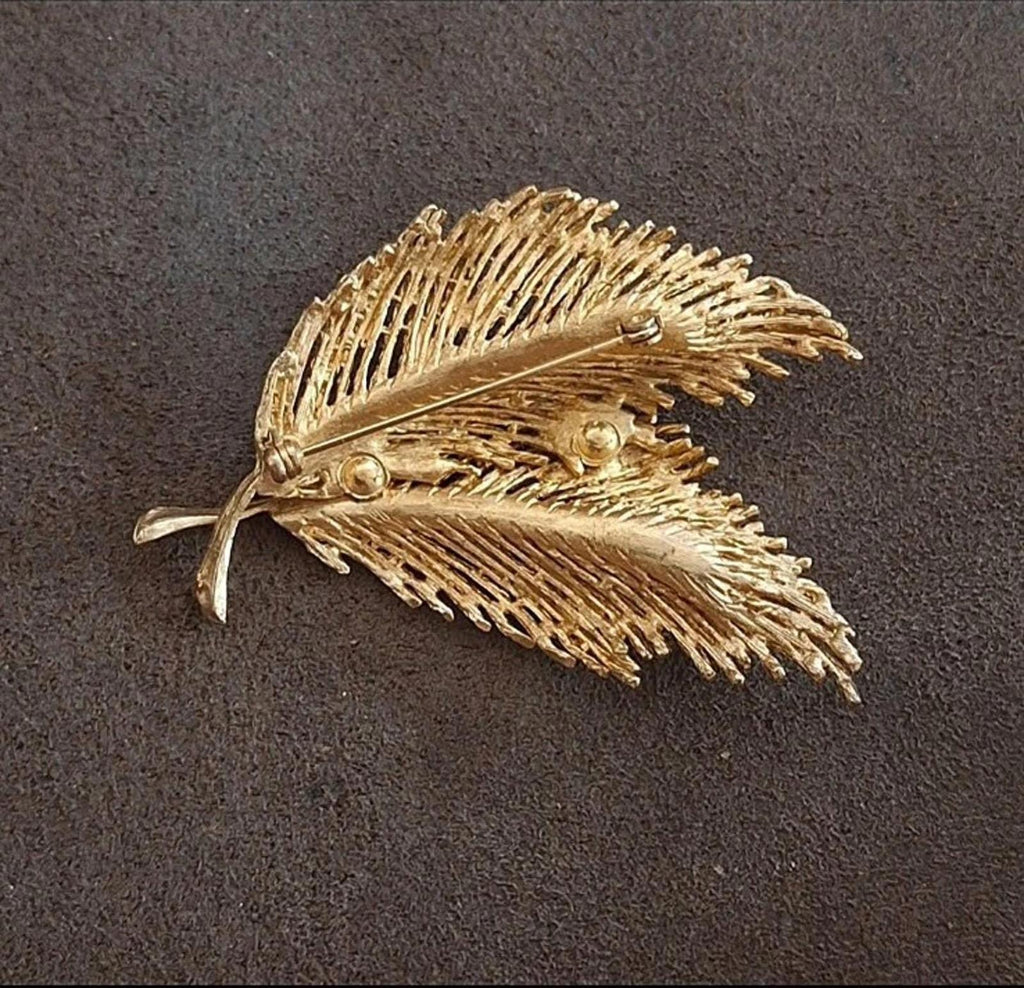 Gold-tone feather leaf pin brooch, front view with round clasp details and leaf accents