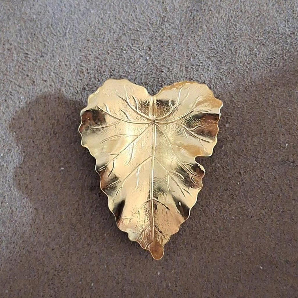 Shiny gold-tone leaf scarf clip with intricate veins and scalloped edge