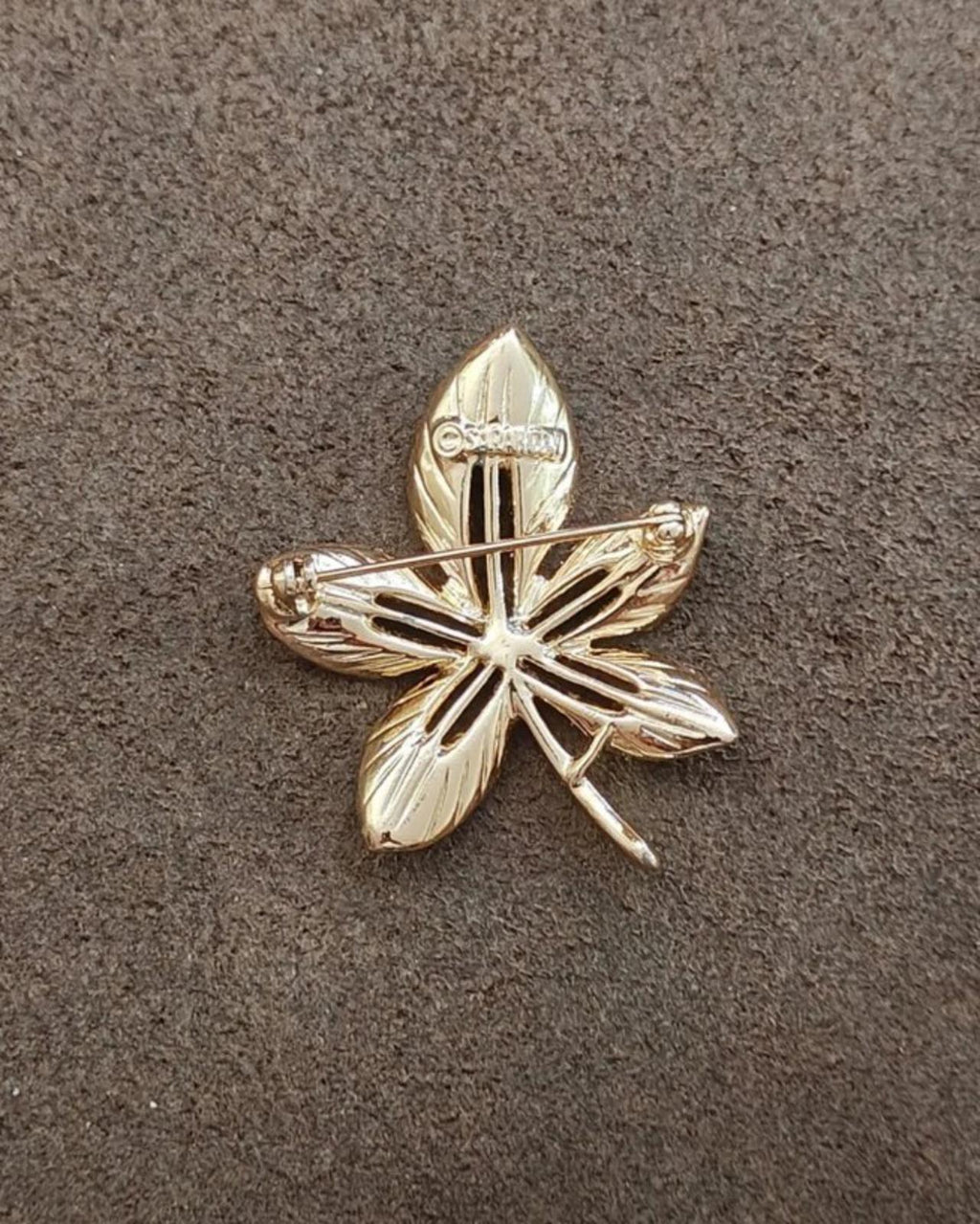 Gold-tone leaf flower brooch with raised ridges and small hinge-like bar accents
