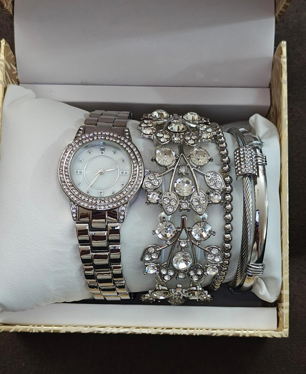 Silver-tone women’s watch set in open box with round rhinestone dial and stacked bracelets
