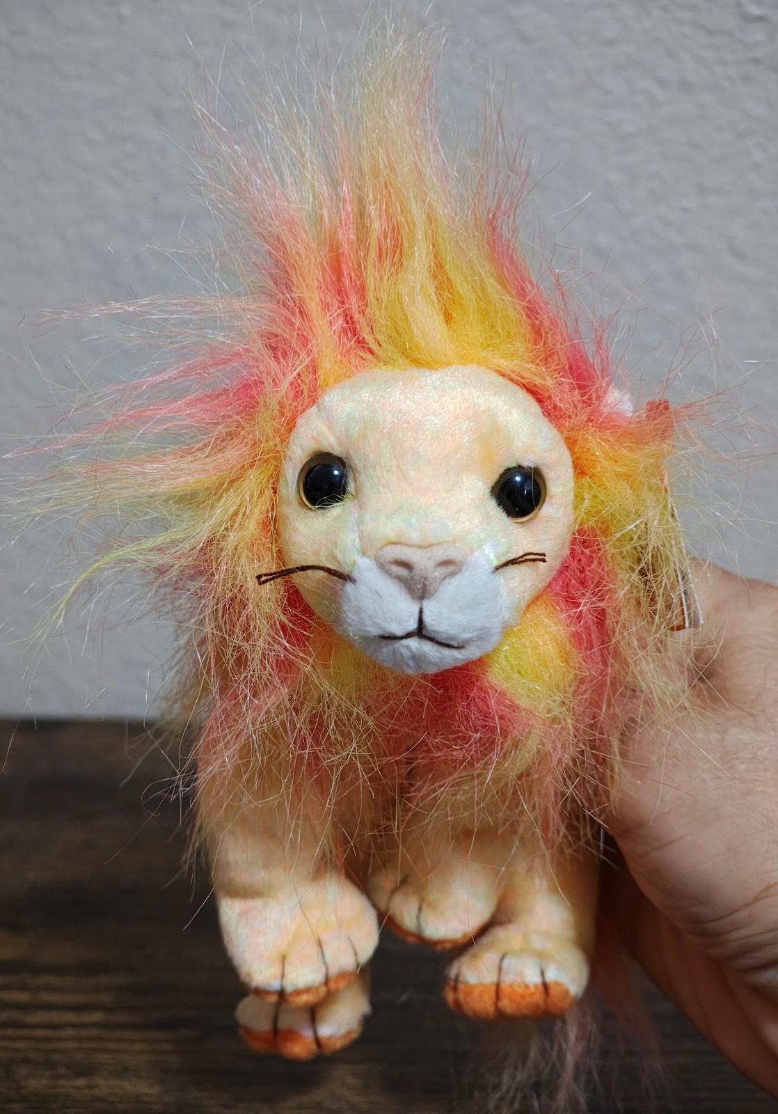 Rainbow-furred lion beanbag plush facing forward, orange-yellow-pink fur