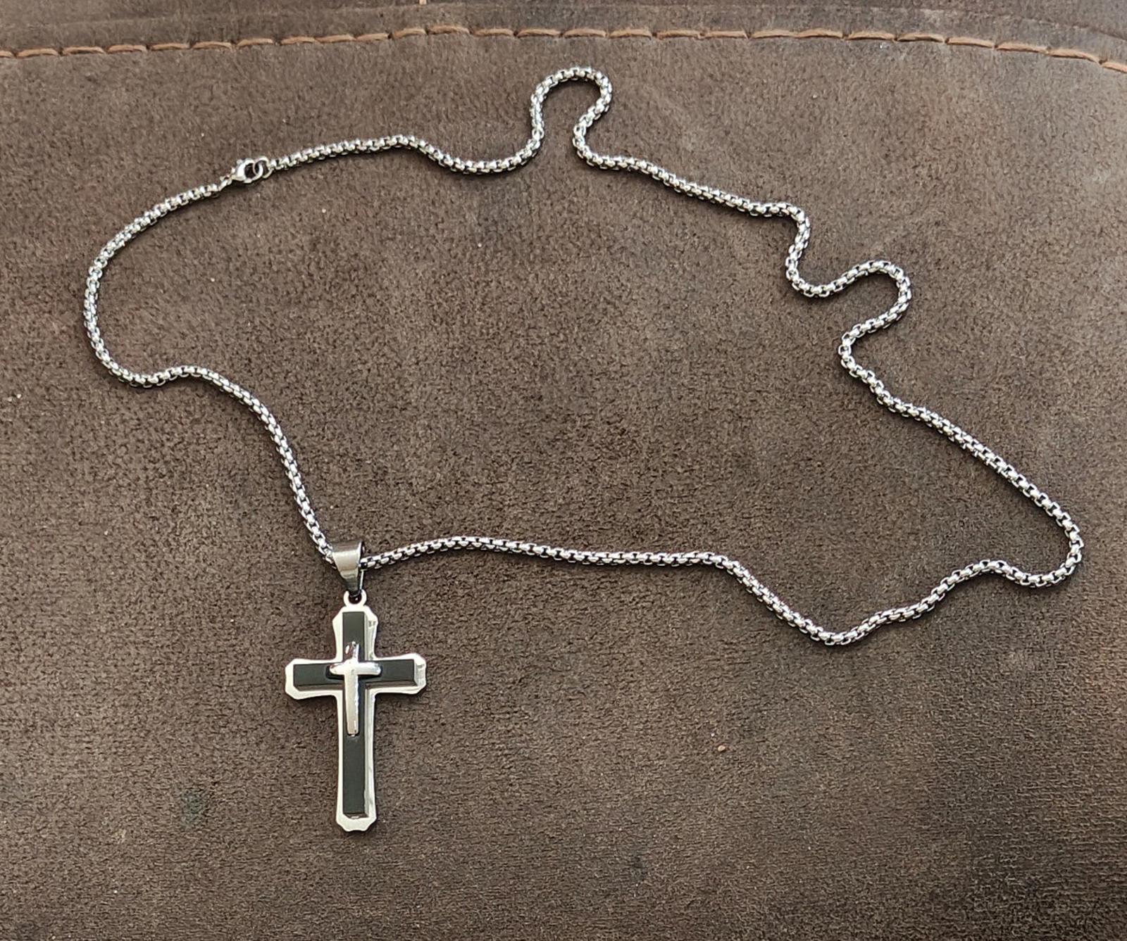Silver-tone chain with small cross pendant necklace laid flat