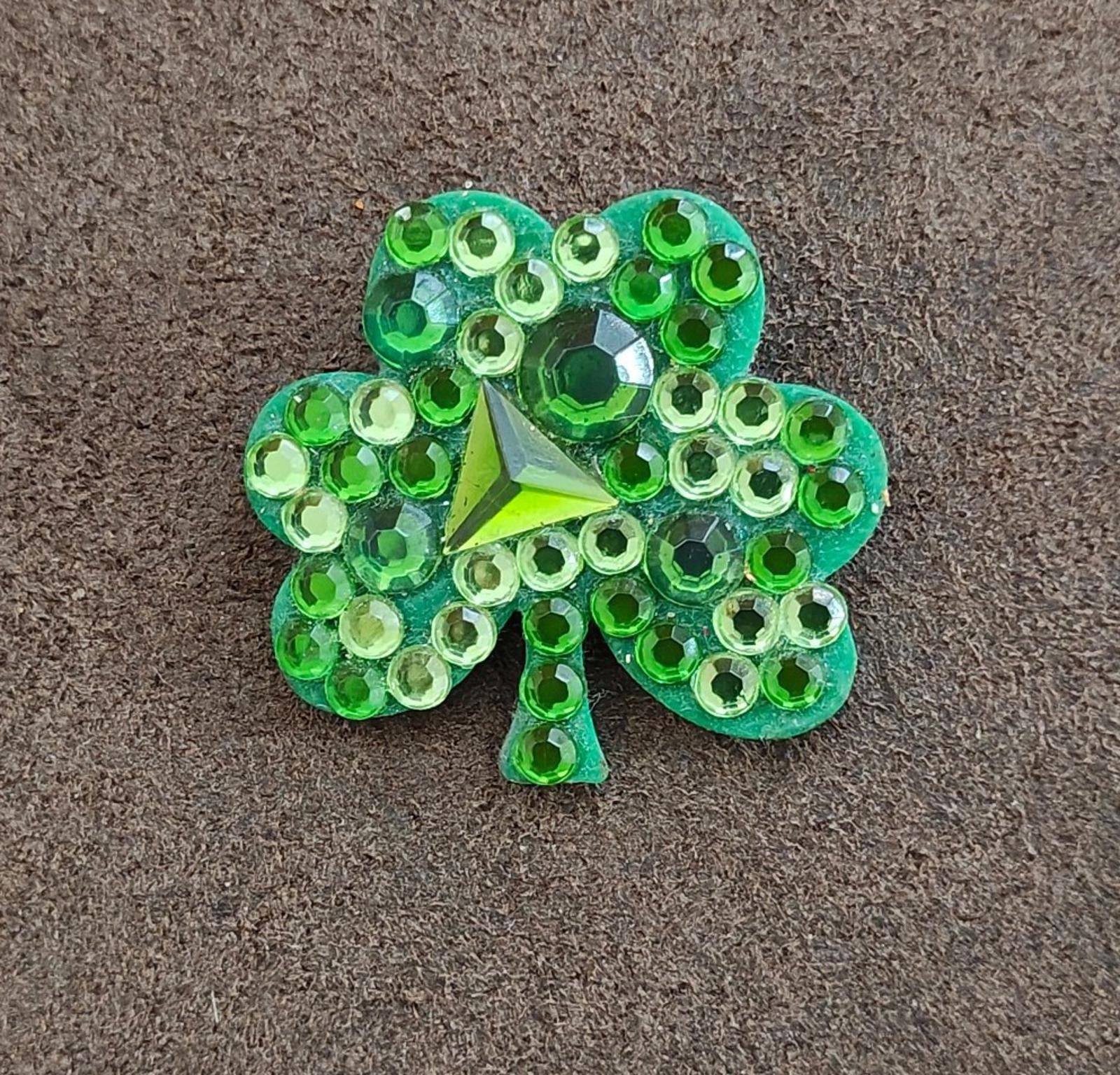 Green jeweled shamrock brooch pin with star center and clustered faceted stones