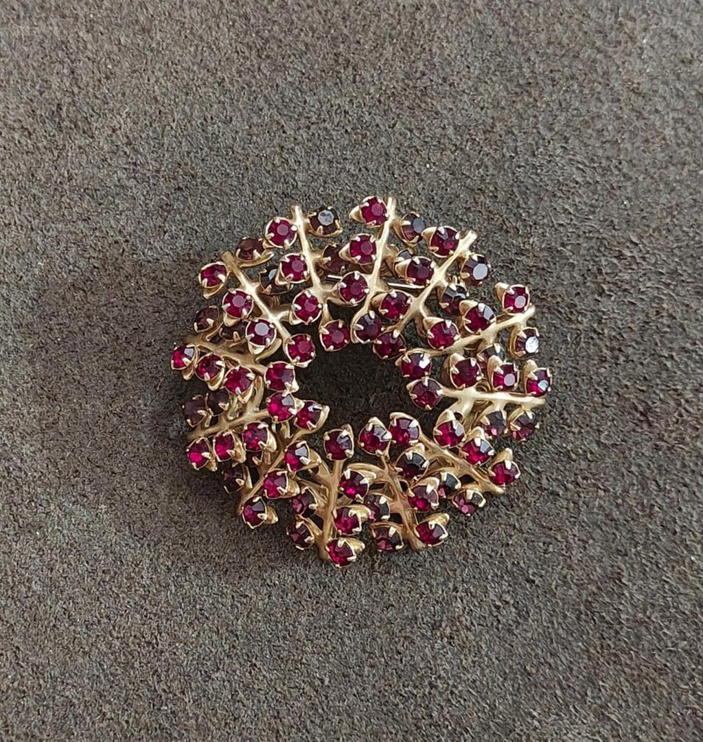 Gold-tone maroon rhinestone brooch pin, top view of sparkling wreath design