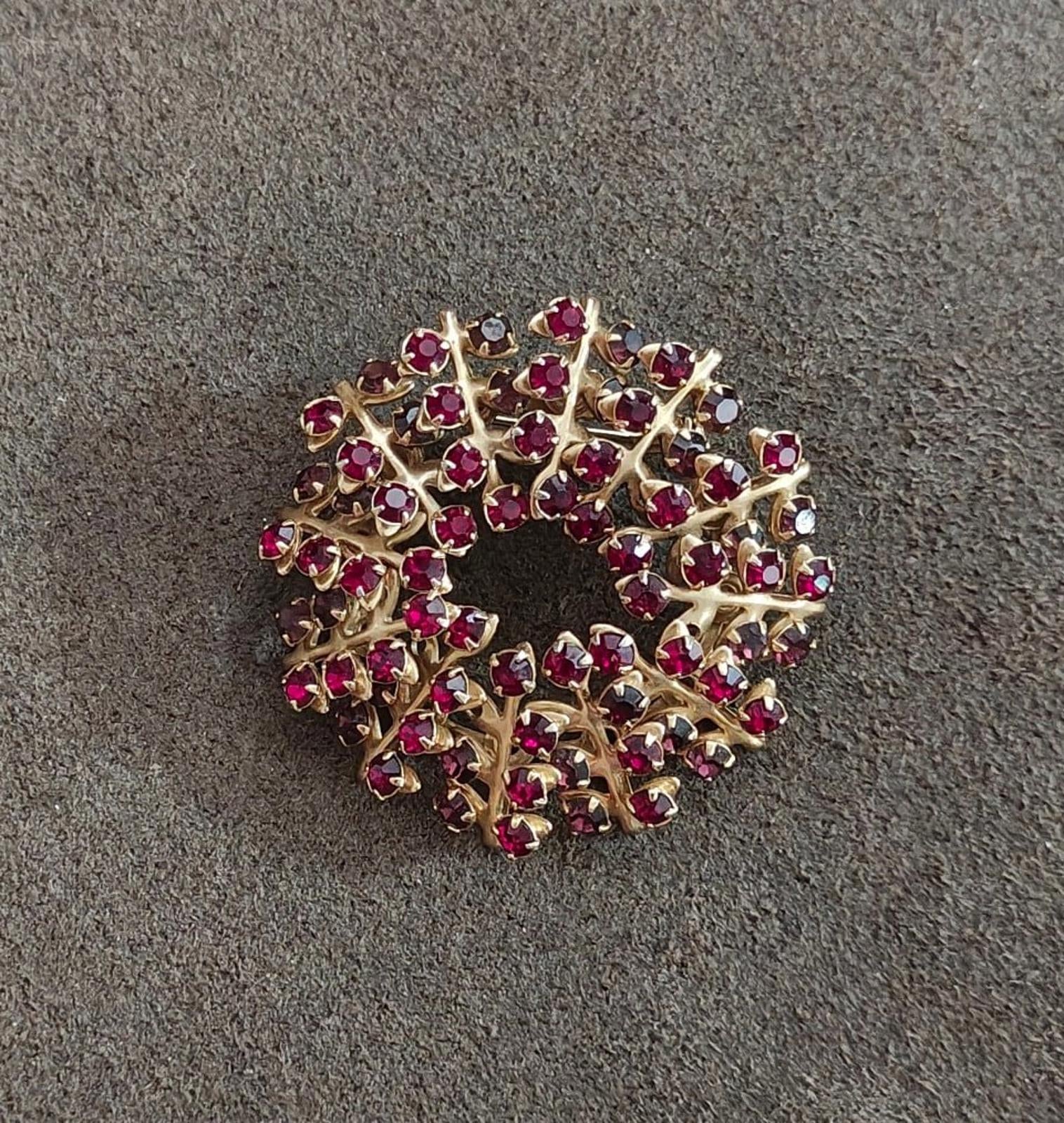 Gold-tone maroon rhinestone brooch pin, top view of sparkling wreath design