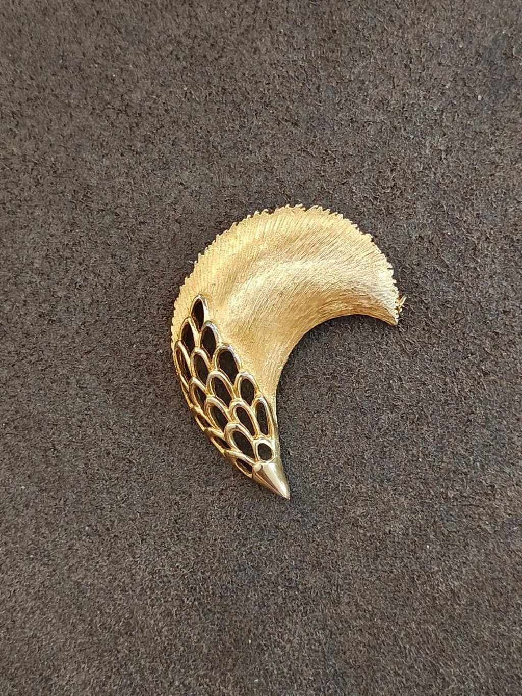 Gold tone feather plume brooch with curved textured top and openwork net detail
