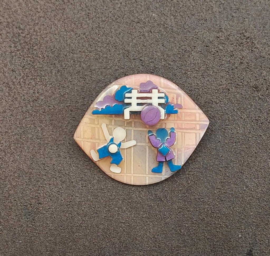 Enamel lapel pin with blue and purple little people on house mural with purple clock