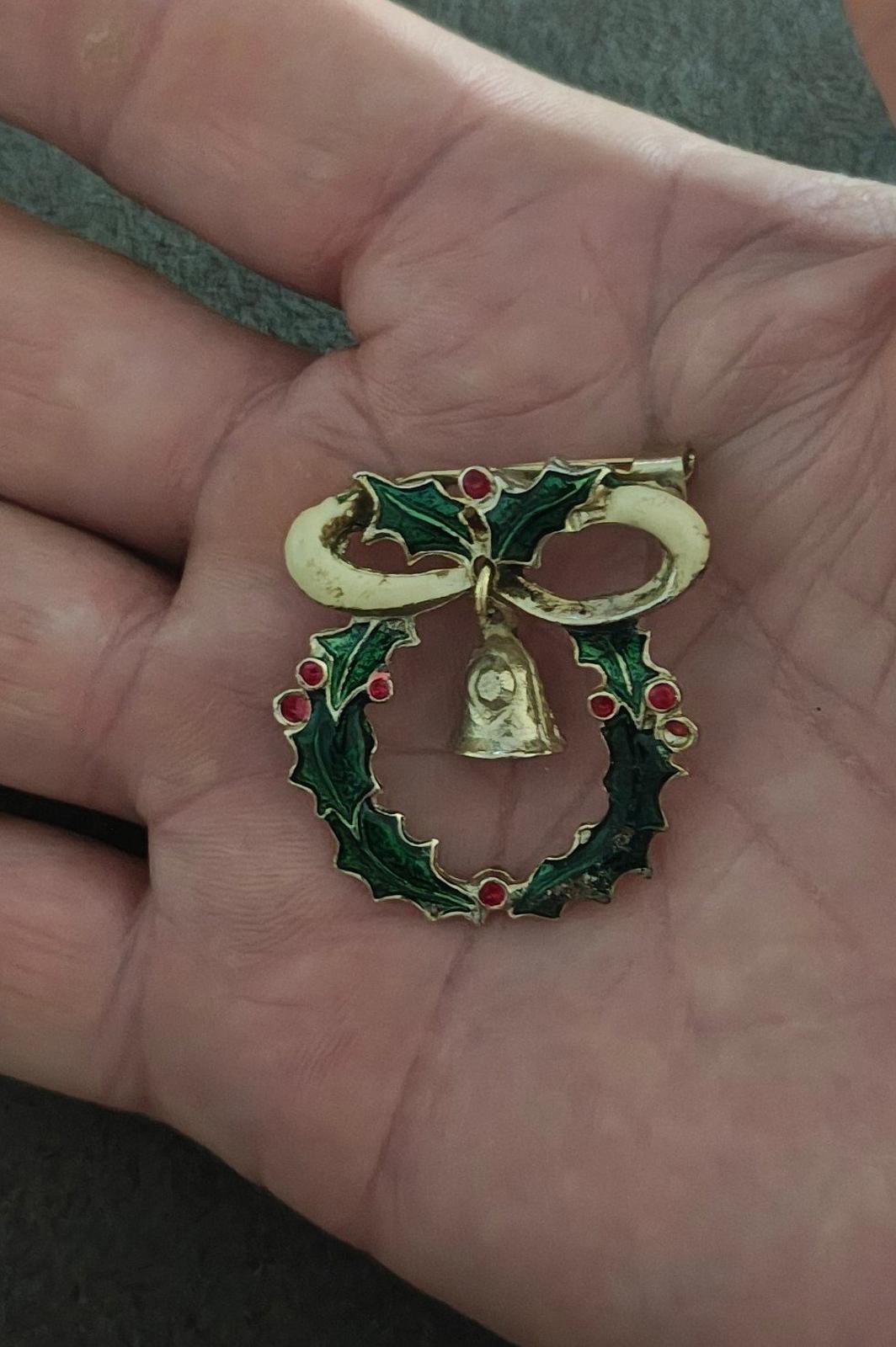 Christmas wreath pin with green enamel leaves, red berries, gold bell and bow detail