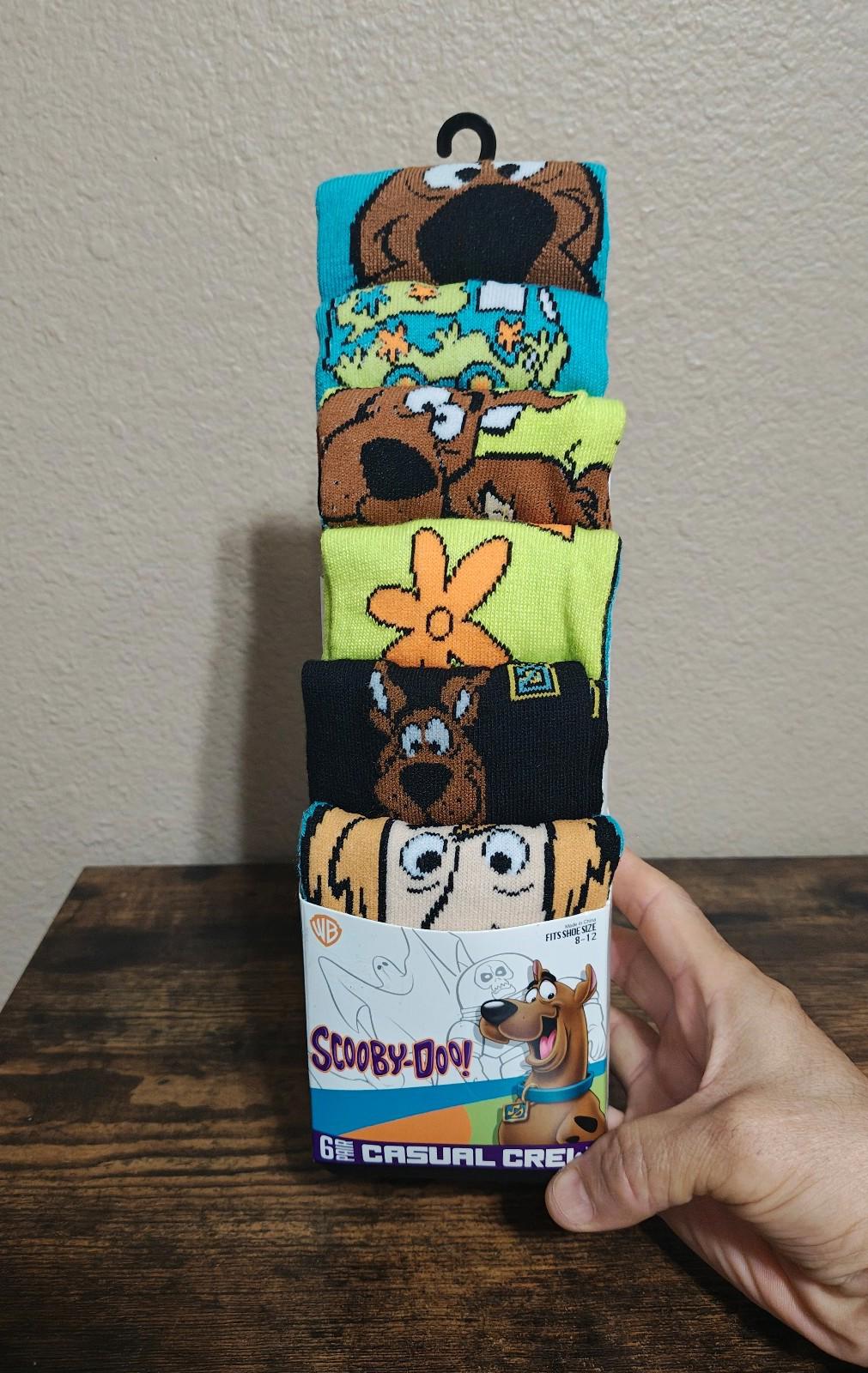 Men's crew socks 6-pack in colorful character prints, shown in retail box.