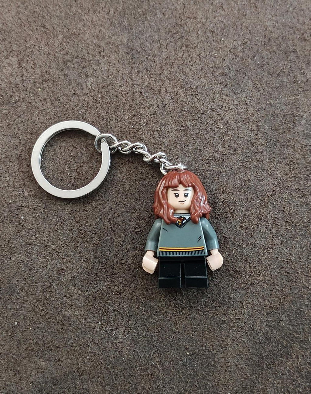 LEGO-style minifigure keychain with brunette hair, teal top, dark legs, silver chain ring