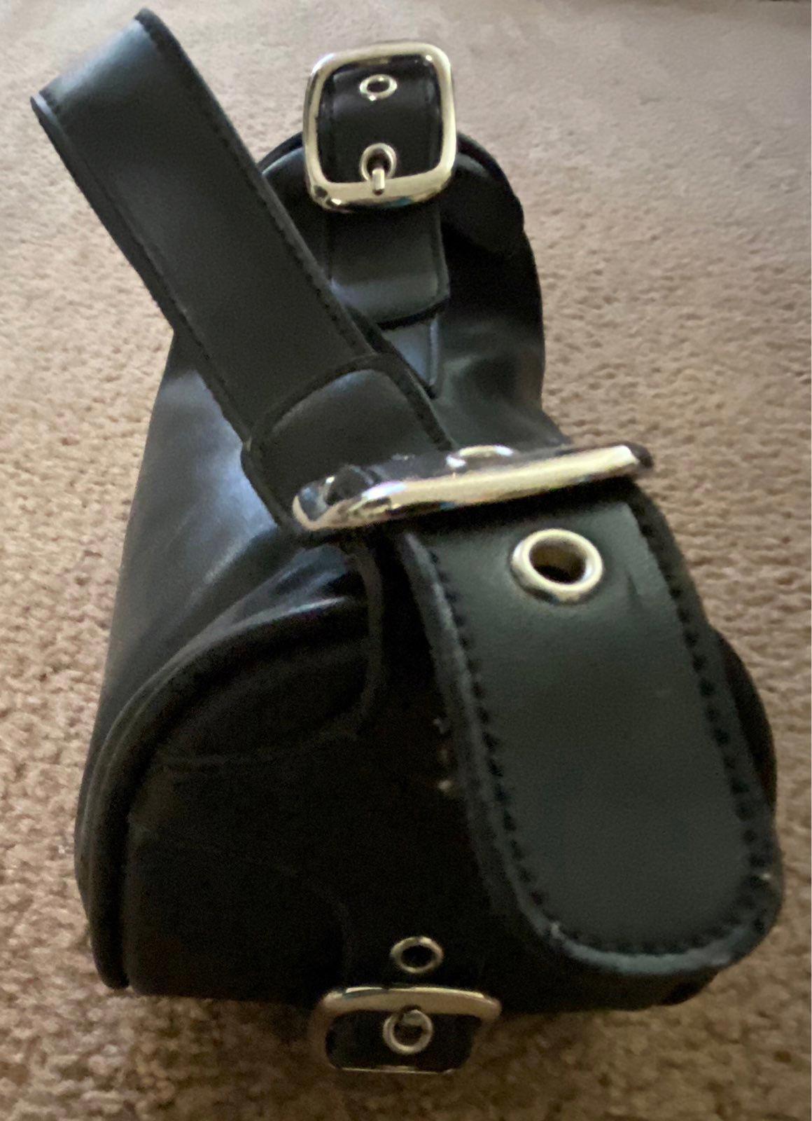 Black leather purse with double strap buckles and metal rings at base