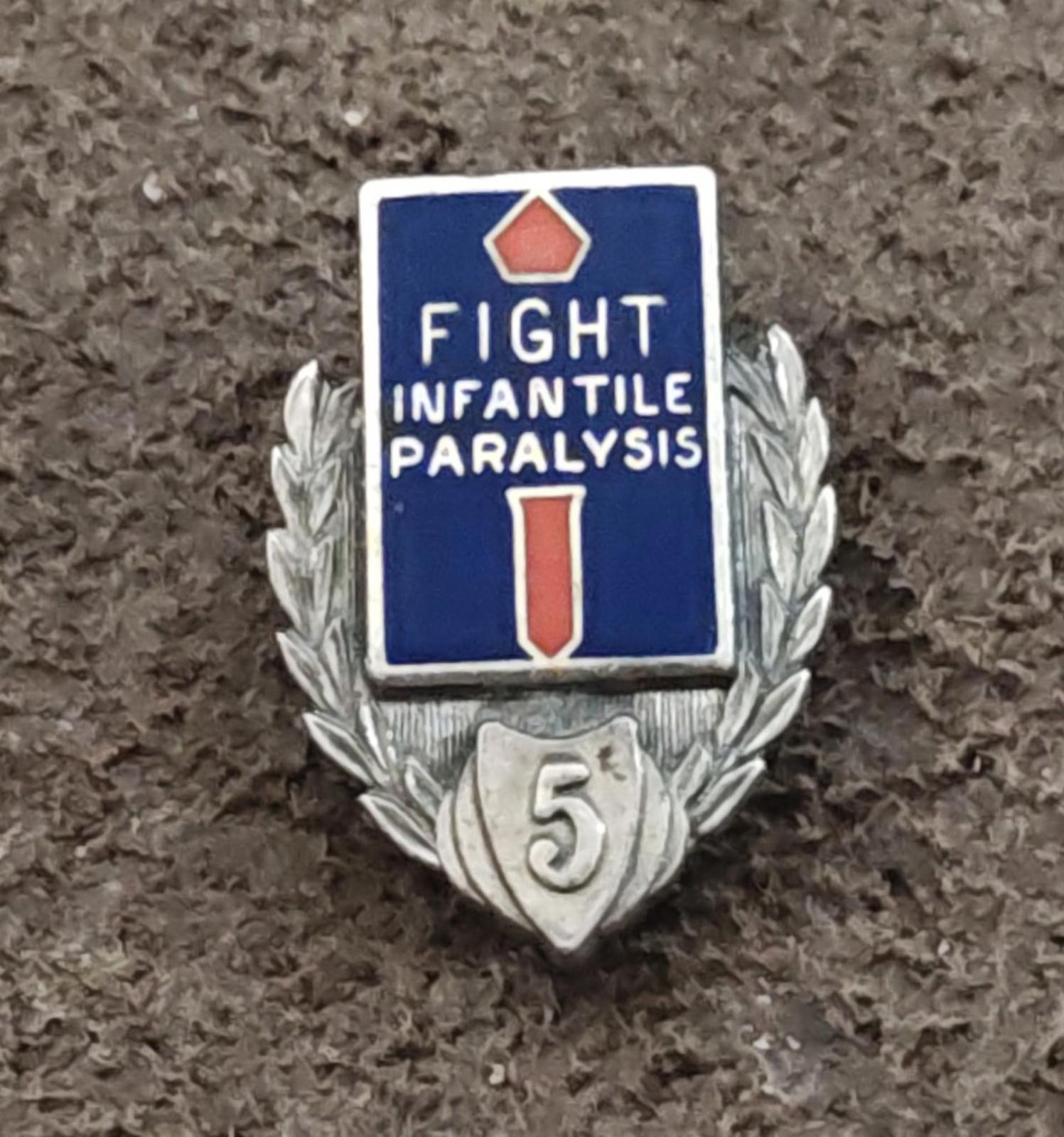 Front view of silver enamel badge pin with blue square and red/white symbols