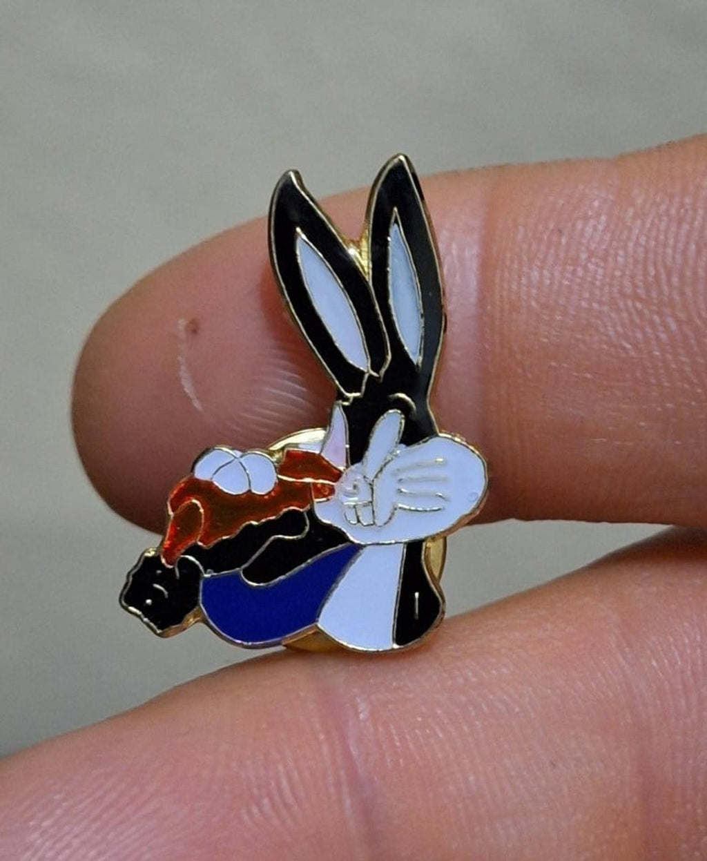 Bugs Bunny enamel pin holding a carrot, close-up; black ears, white face, blue body