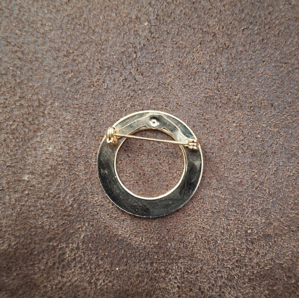 Goldtone round pin brooch back with clasp and needle pin visible