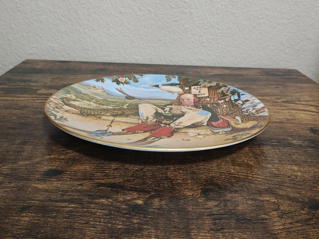Collectible decorative plate lying flat with April Fool artwork and blue sky