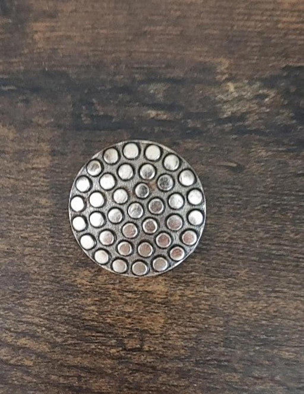 Round scarf clip face featuring a concentric dotted pattern in silver tone